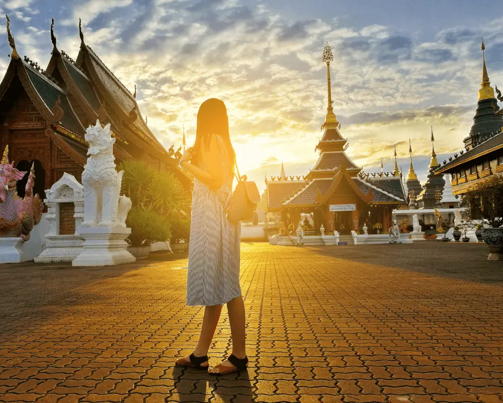 A picture of a woman standing in front of temples in Chiang Mai