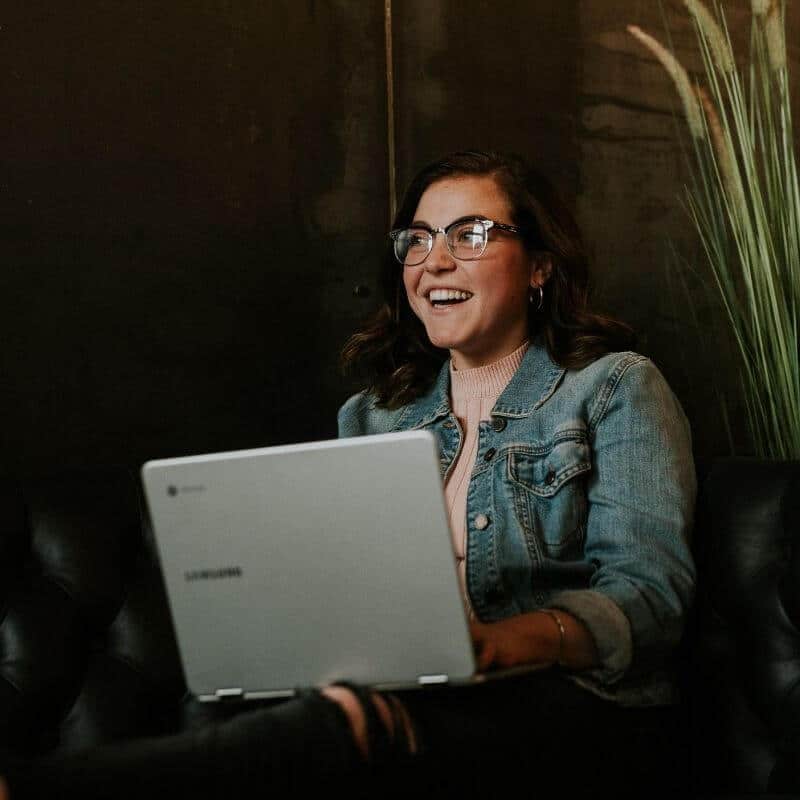 Woman smiling with a laptop on her lap