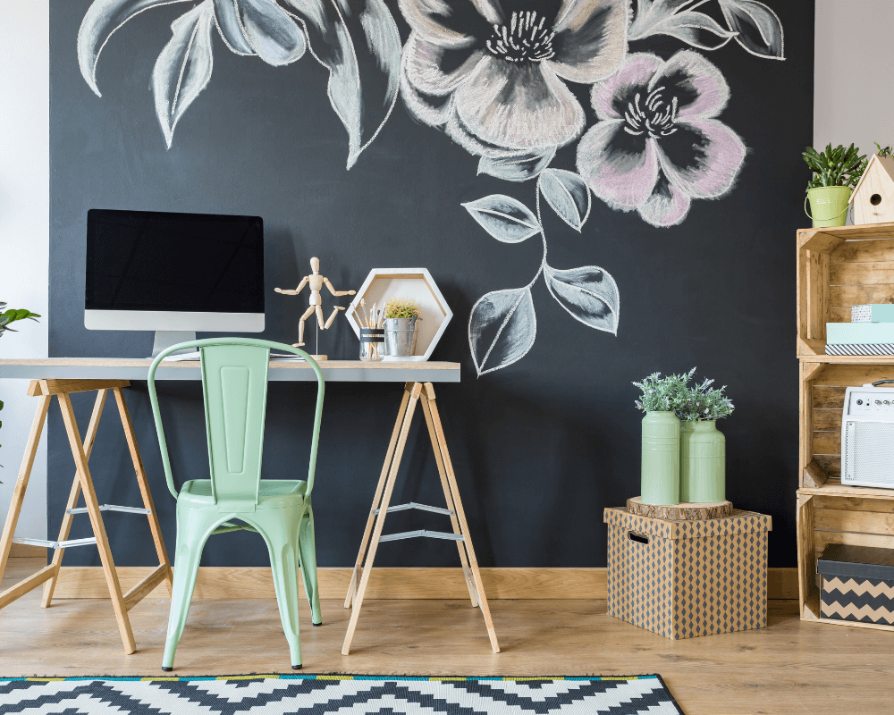 An office with a chalk board feature wall with a drawn flower image