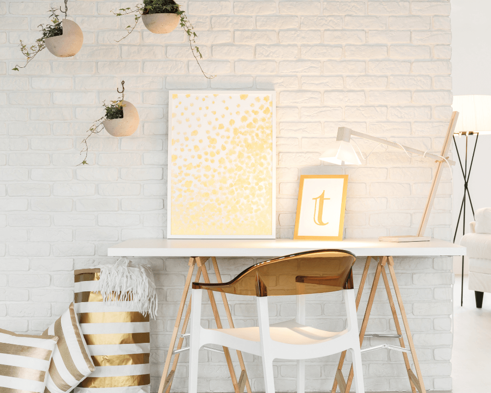 A home office that has been decorated in white and gold furniture and office accessories