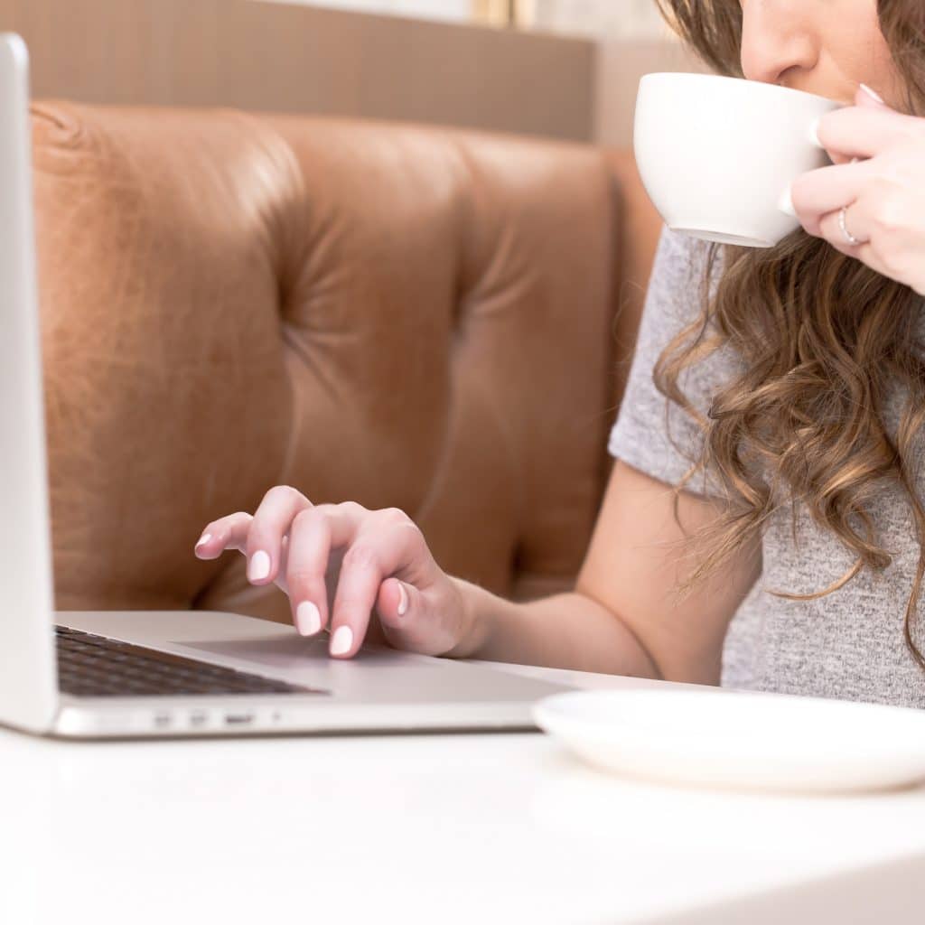 A virtual assistant on a laptop sipping coffee
