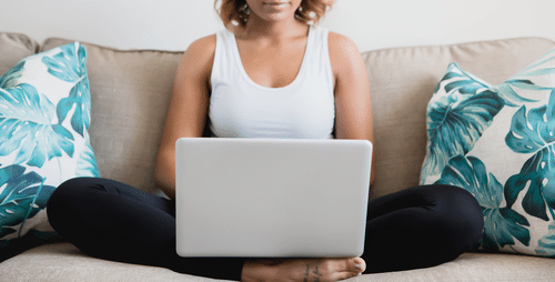 woman on couch with laptop cross legged