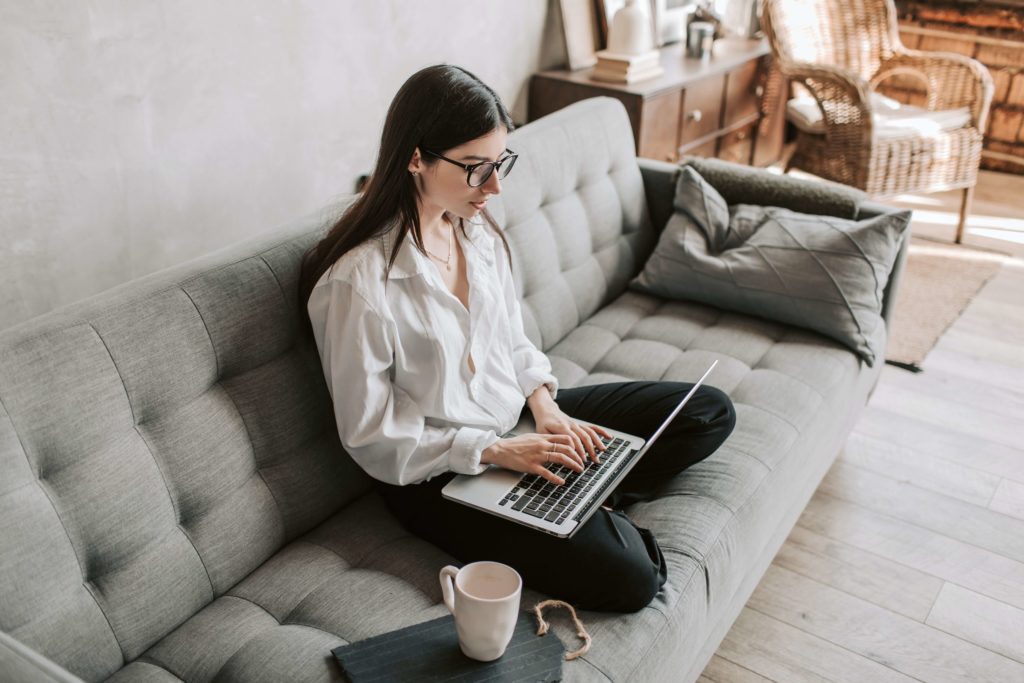 girl on couch working on laptop