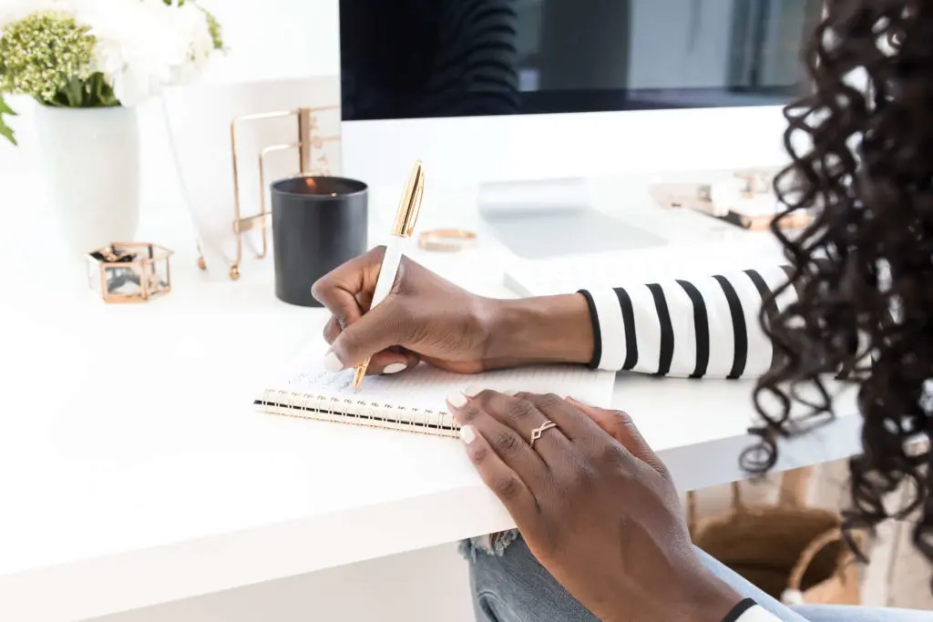 woman writing in notepad