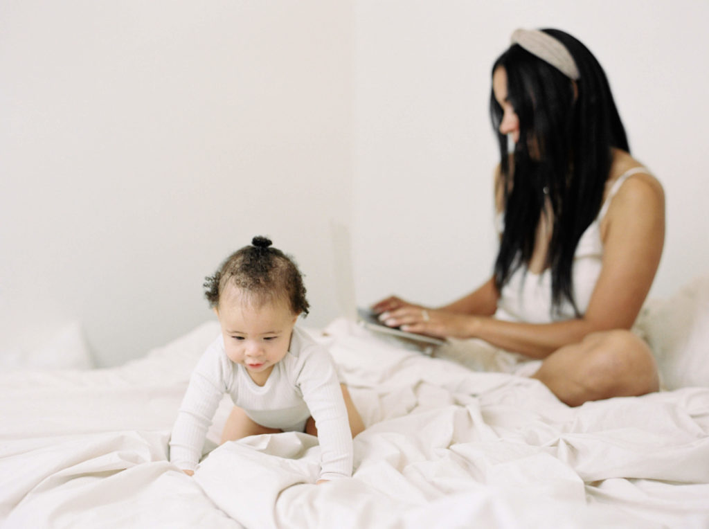 mom working from bed with baby