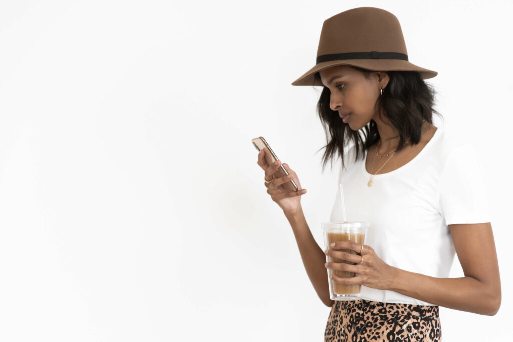 woman holding phone and coffee
