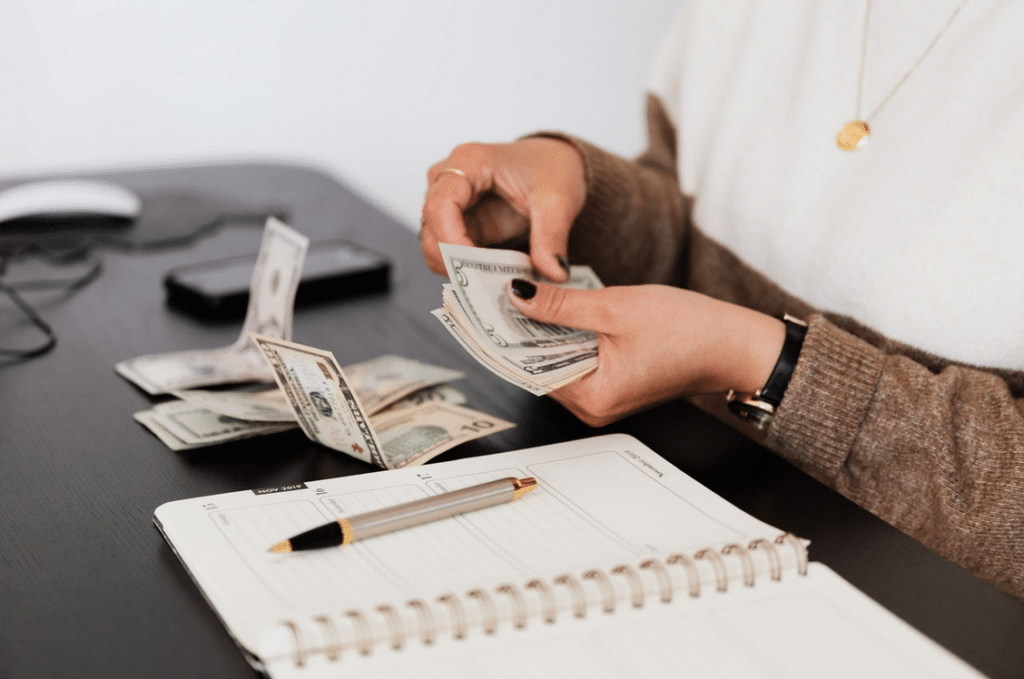 Woman counting money doing accounting on notebook