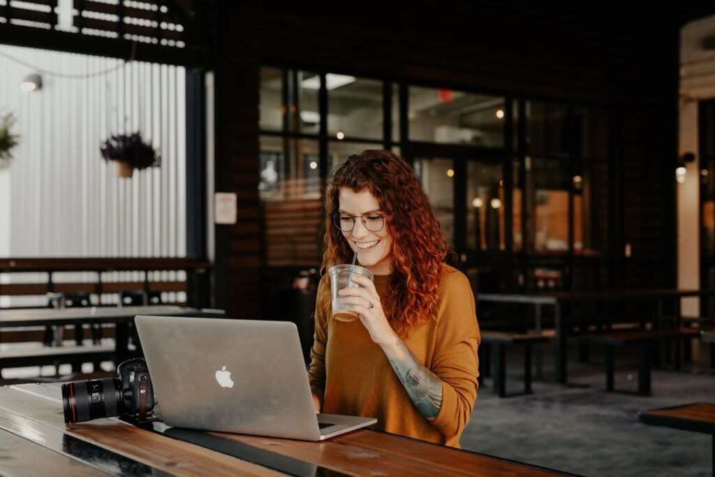 woman sitting at coffee shop working online virtual assistant successful